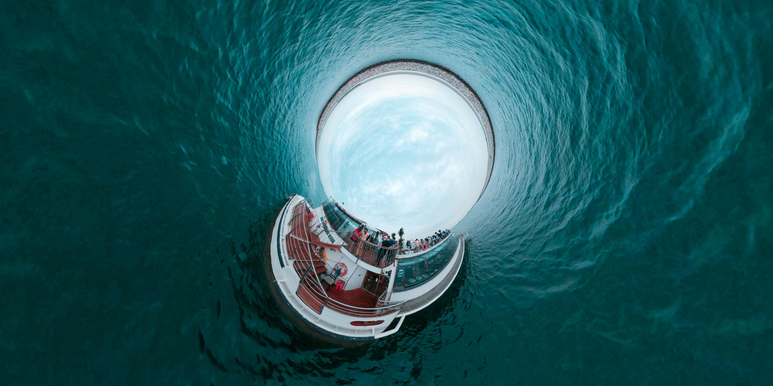A stunning tiny planet effect image featuring a cruise ship surrounded by ocean water, capturing a unique perspective.