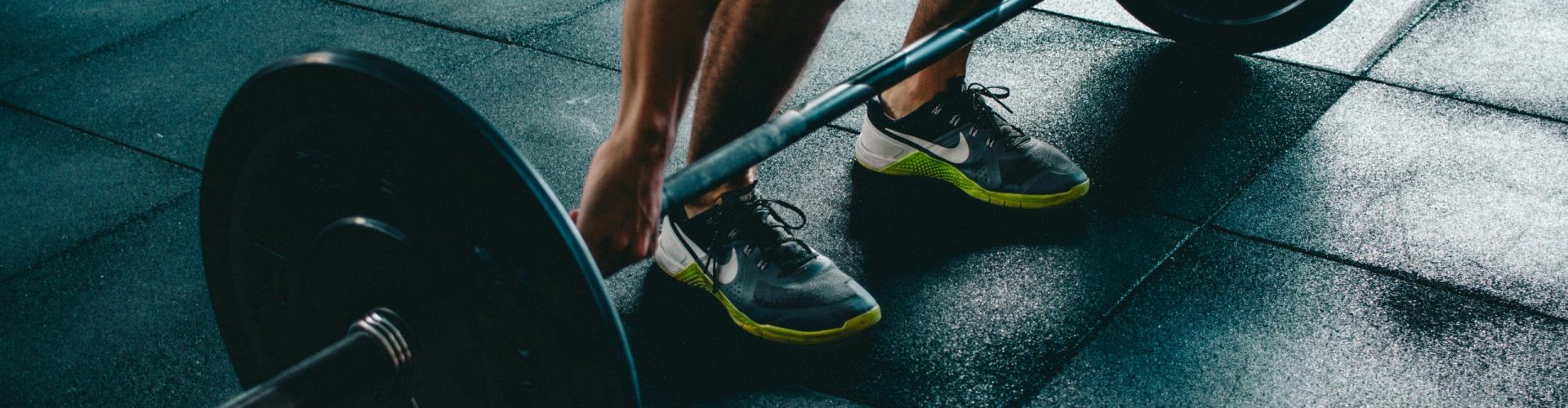 Man performing a deadlift exercise in a gym, demonstrating strength and fitness.